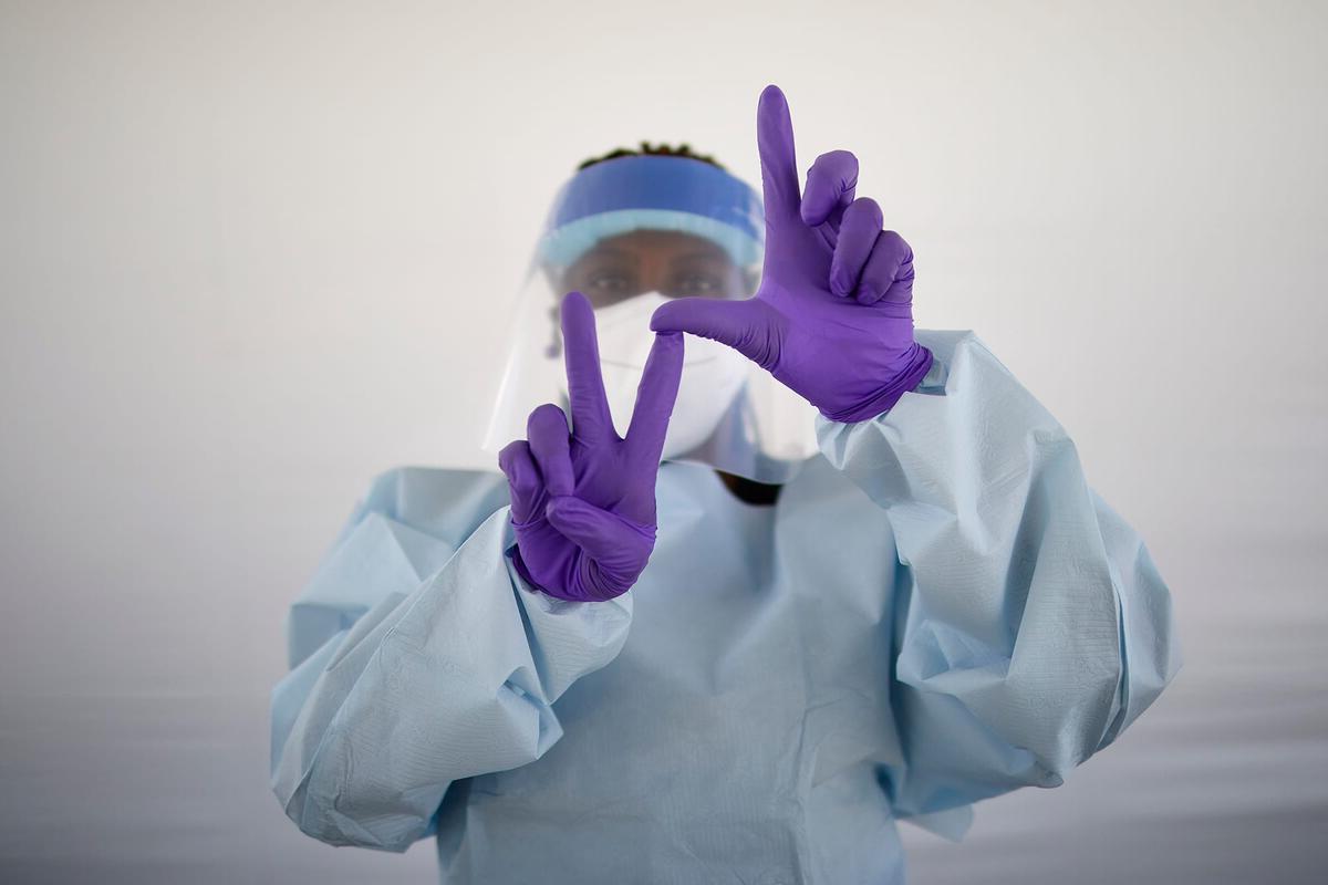 医学院的工作人员在手术室里做L.V. sign with hands